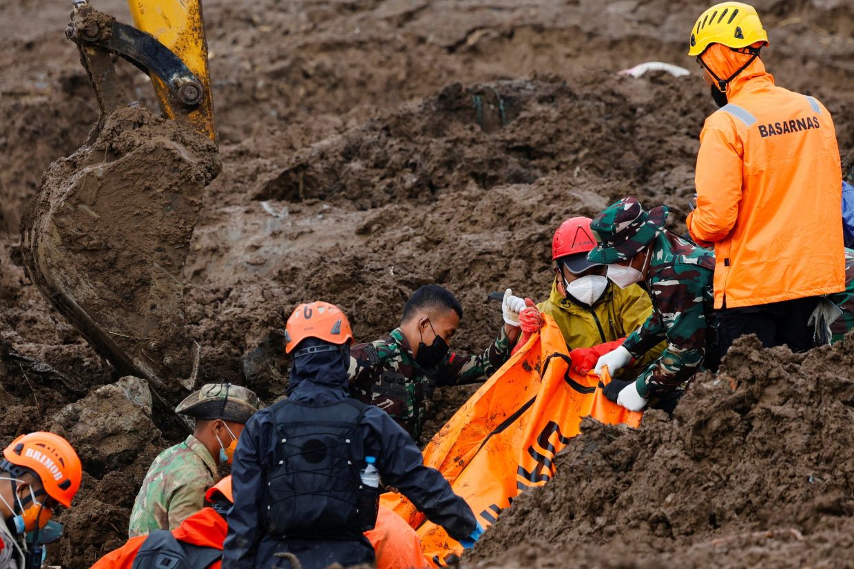 Indonesian rescue members carry a body bag containing the remains of a victim from the site of a landslide following heavy rains in Pasir Langu village, West Bandung regency, West Java province, Indonesia, on Tuesday, January 27, 2026. -- Photo: REUTERS/Ajeng Dinar Ulfiana