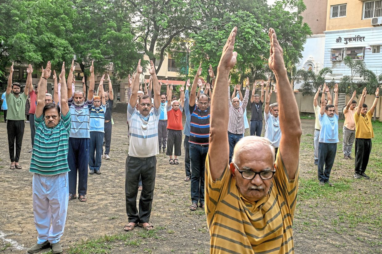 The RSS holding a meeting in Mumbai. (Right) Volunteers exercising at a community park in Nagpur. — Atul Loke/The New York Times