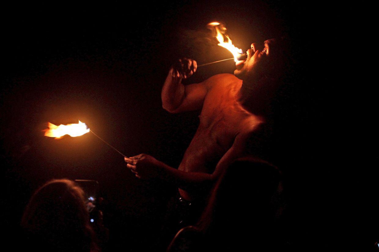 A fire juggler mesmerising attendees at the charity dinner.