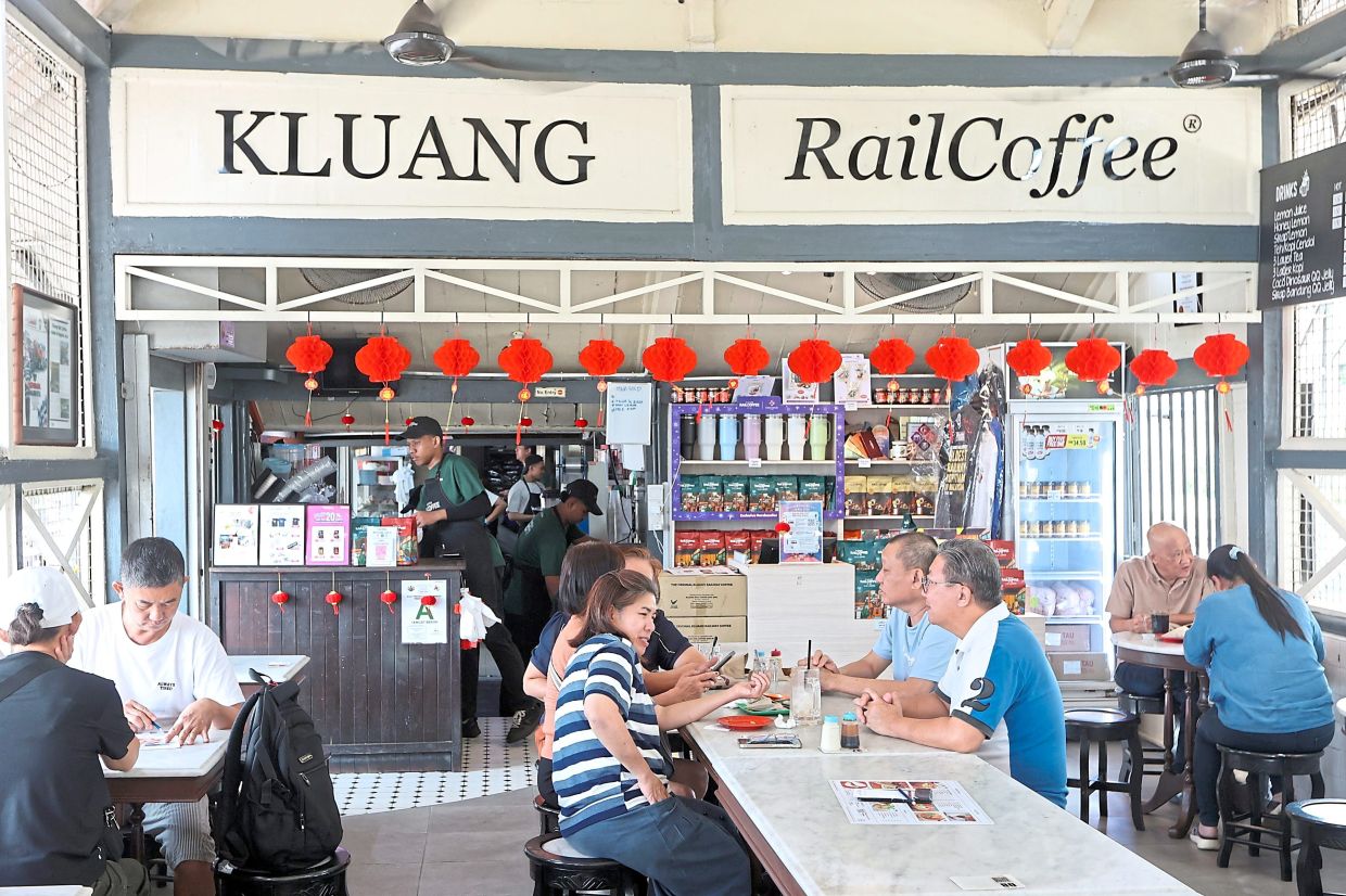 People having breakfast at a coffeeshop next to the old Kluang railway station.