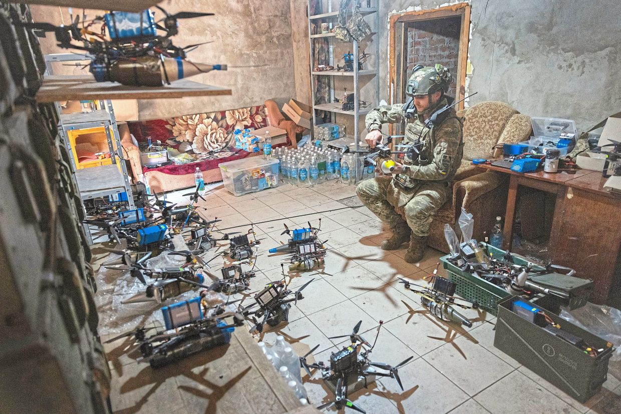 In this file photo, a Ukrainian soldier is seen arming first-person-view, or FPV, drones in the safety of an abandoned house in the Kharkiv region on Aug 24, 2024; (inset) a file photo of a Ukrainian artillery unit monitoring for drones in the Dnipro region on Oct 17, 2025. —David Guttenfelder, Tyler Hicks/The New York Times