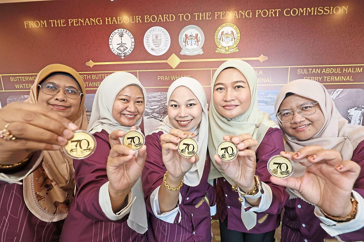 Penang Port Commission staff with the organisation’s commemorative 70th anniversary gold coin. 