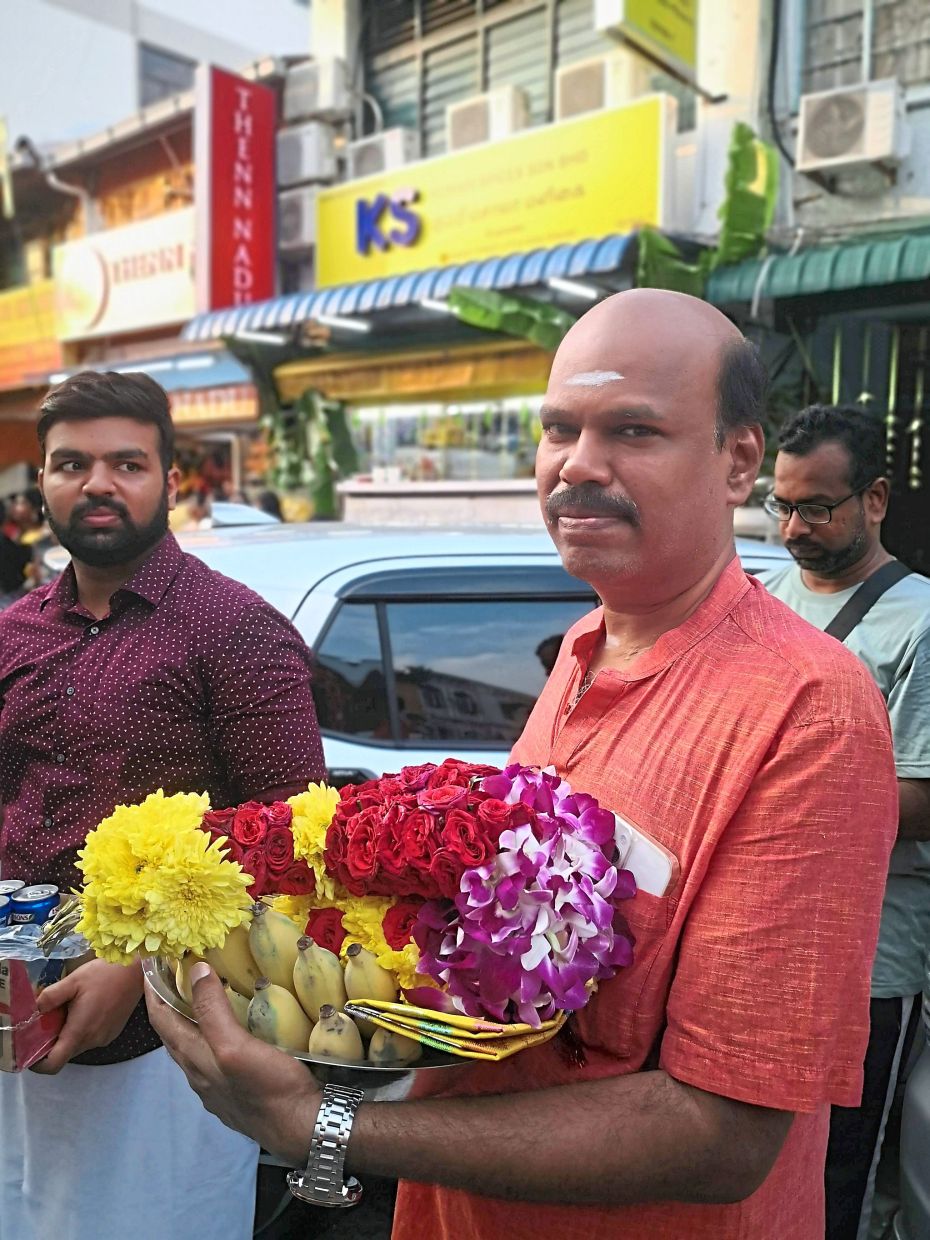 Devotees wait patiently with their offerings for the chariot.