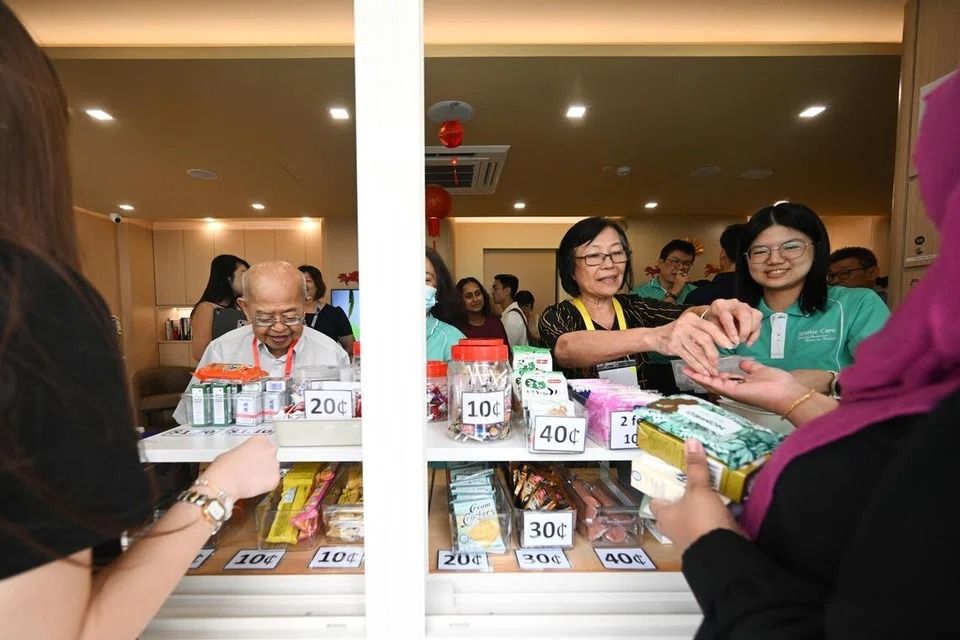 Seniors selling snacks to passers-by at the newly opened wing at PCF Sparkle Care @ Kreta Ayer on Jan 30. - ST
