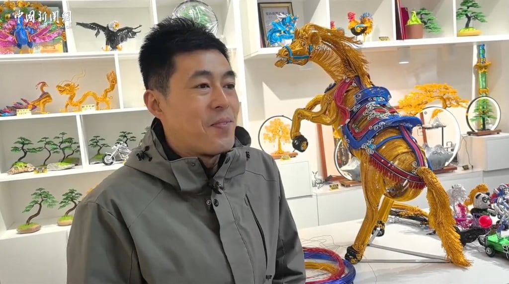 Yang stands proudly alongside his latest colourful creation. - Photo: ChinaNews