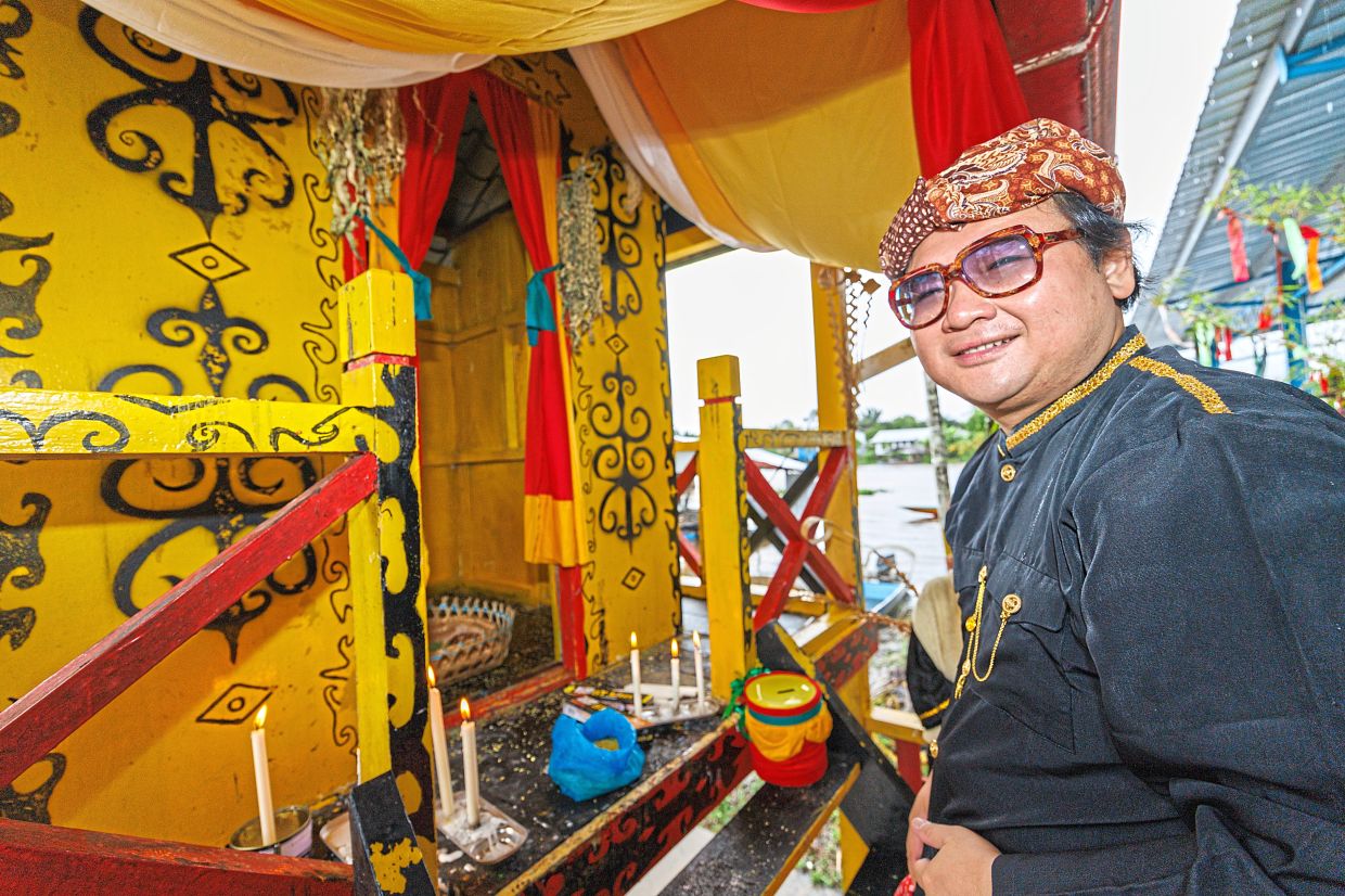 Chung presenting an offering to the belisieng in Kampung Medong.