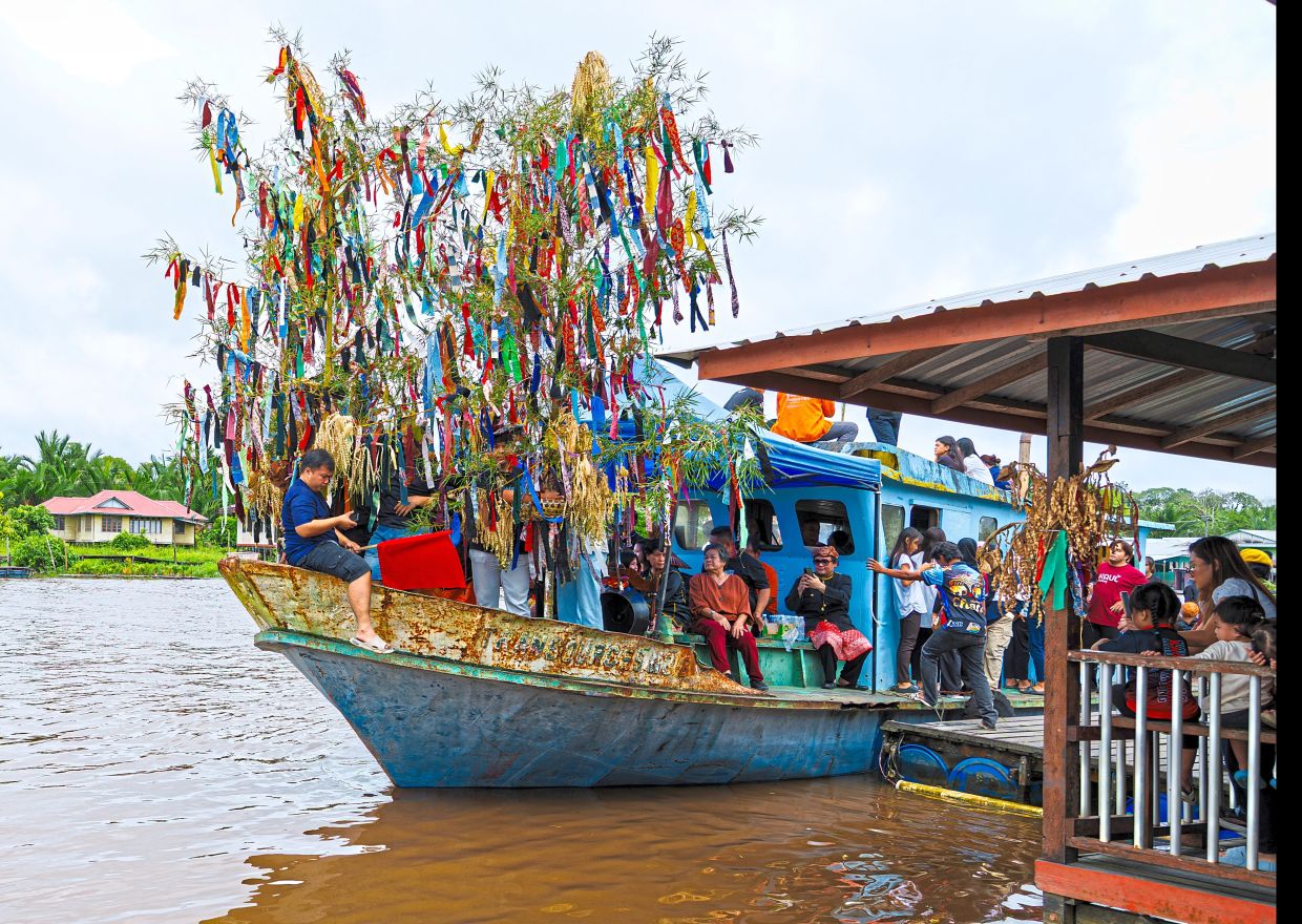 The lead boat carrying the seraheng setting off from the jetty at Kampung Medong.