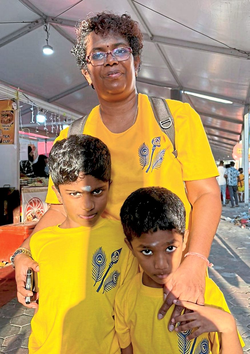 Starting them young: (Top) Lenon (left) and Kalapana with their daughter on their first trip as a family to Batu Caves to celebrate Thaipusam. (Right) Thanaletchume’s five-year-old son (right) carried ‘paal kudam’ up the stairs for the first time, while her eldest son (left) has carried it a couple of times.
