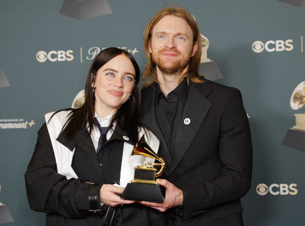 Billie Eilish and Finneas wearing ICE Out pins pose with the award for Song of the Year for 'WILDFLOWER' in the photo room during the 68th Annual Grammy Awards in Los Angeles, California, U.S., February 1, 2026. Photo: Reuters