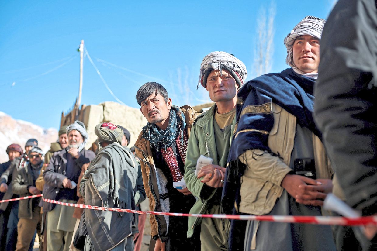 Afghan men wait in line to receive food from a WPF distribution center in Yakawlang, Bamyan province.