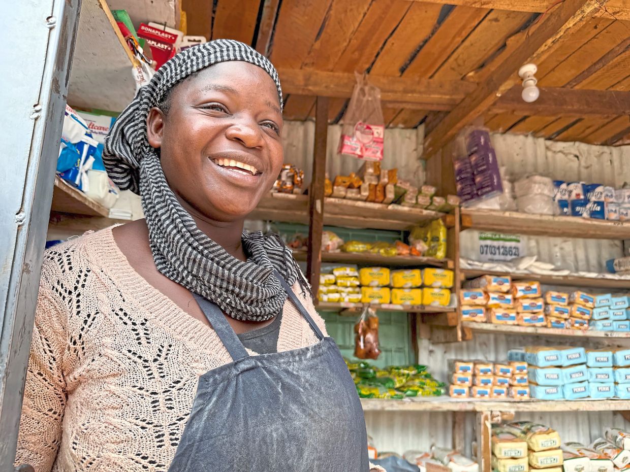 Abongo stands in her store in Kibera. After training and with the help of a loan, the former street vendor set up her business, where she now also employs staff. 