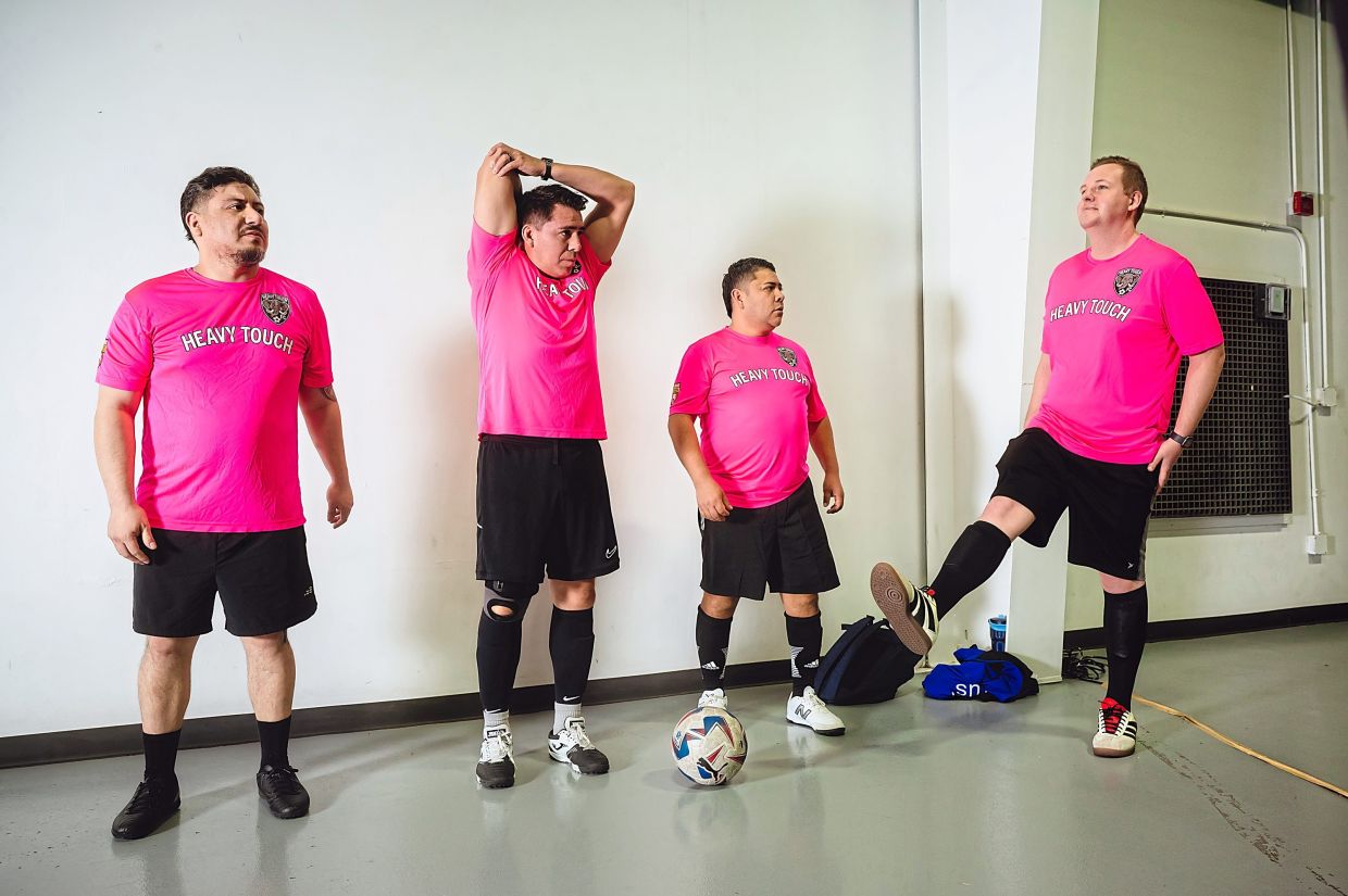 Heavy Touch FC players stretch before a Man v Fat soccer league game.