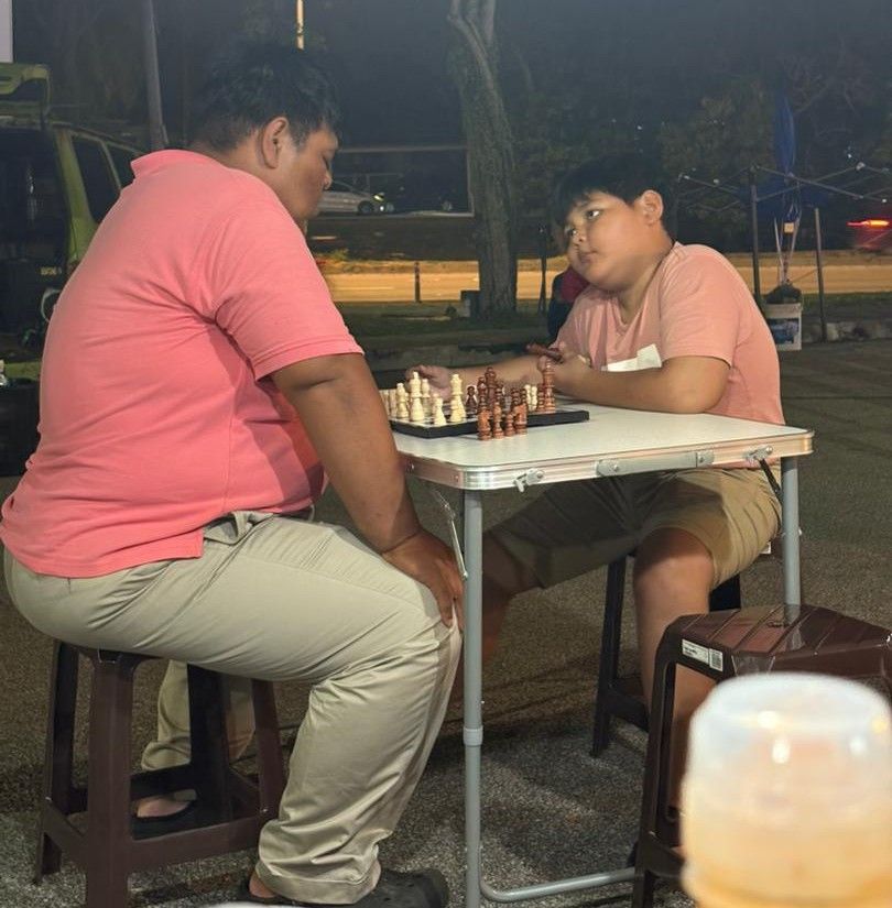 Muhammad Nur Raziq (right) plays chess with his father, Muhammad Nur Qisti.