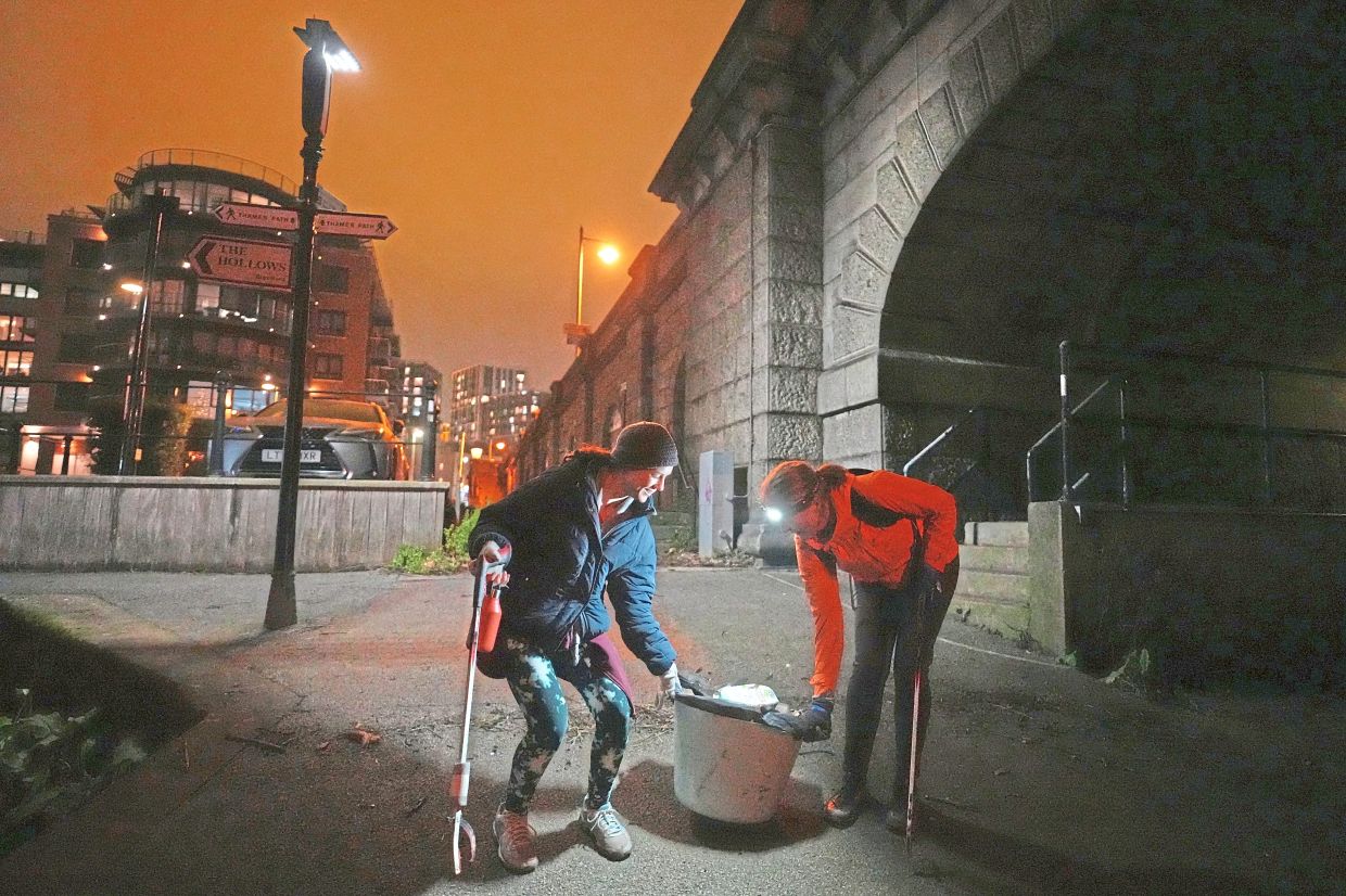 Aside from picking plastic litter from the muddy banks of the River Thames, the group also clears sidewalks of discarded Christmas trees, plant fruit trees and set up cots for the homeless.