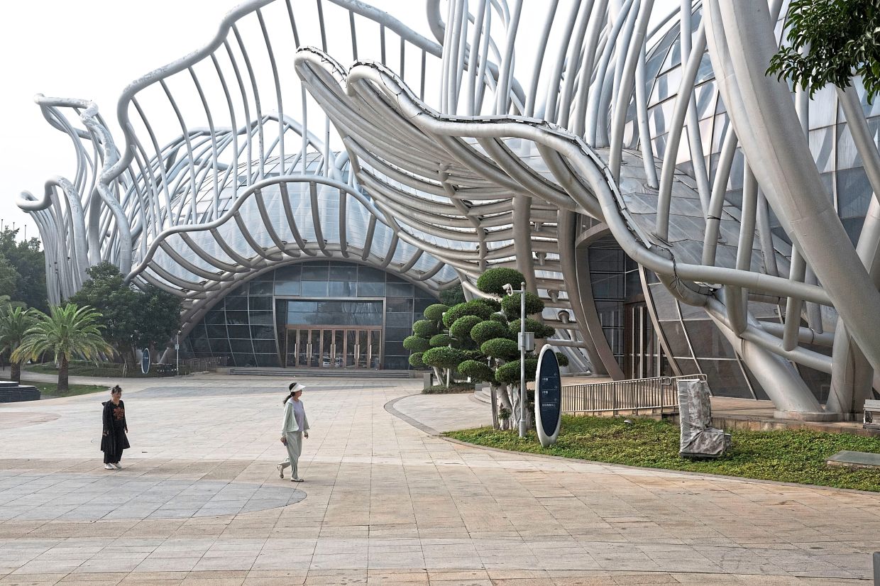 Visitors walking by pavilions of a conference and convention space. 