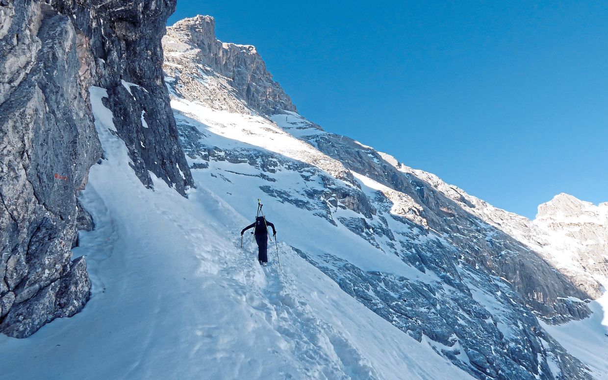 A ski tourer on the Wetterstein mountains. Because of the steep terrain, he carries his skis on his back and uses an ice axe and crampons. — ANGELIKA WARMUTH/dpa