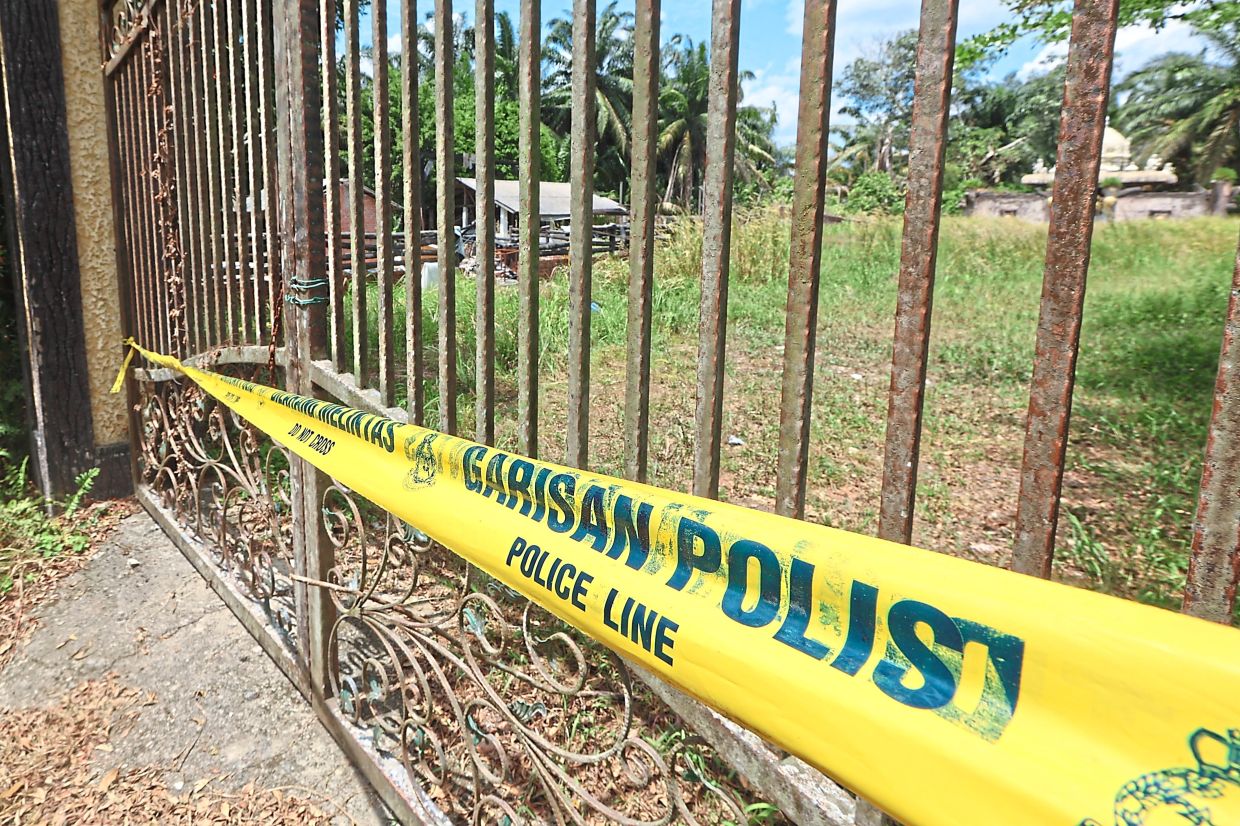 Secluded property: Police tape sealing the front gate of the area with the abandoned houses.