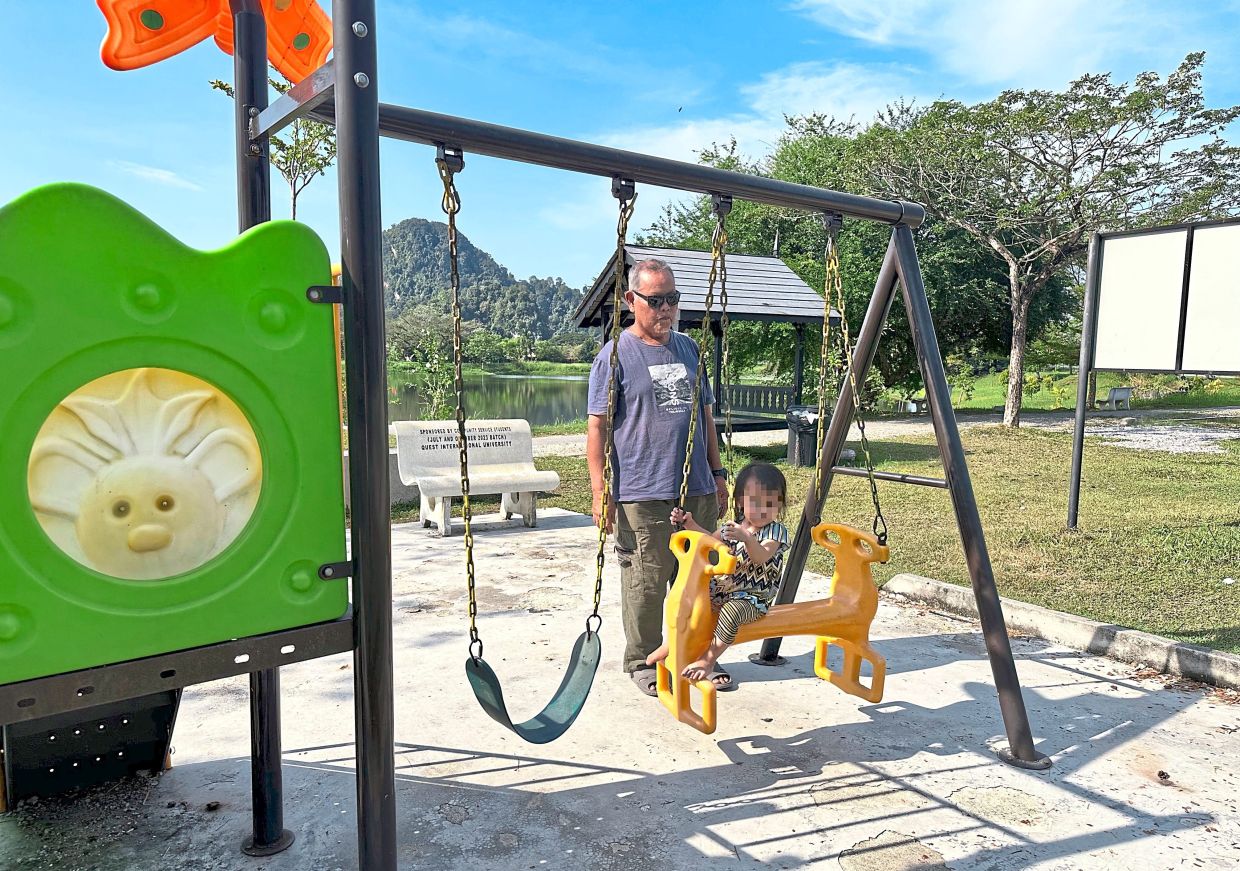 Ahmad Ramli regularly takes his granddaughter to the park.