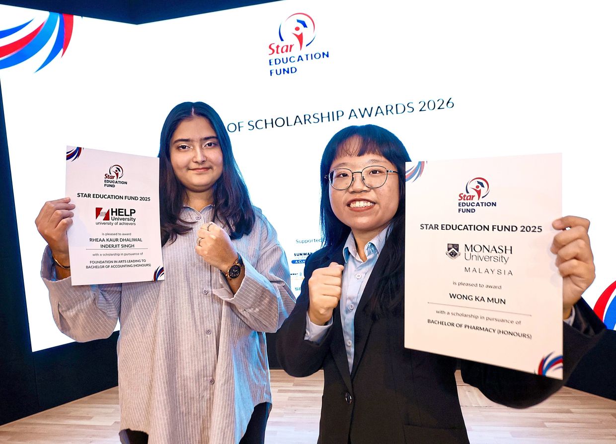 Rheaa (left) and Wong showing off their scholarship certificates. — YAP CHEE HONG/The Star