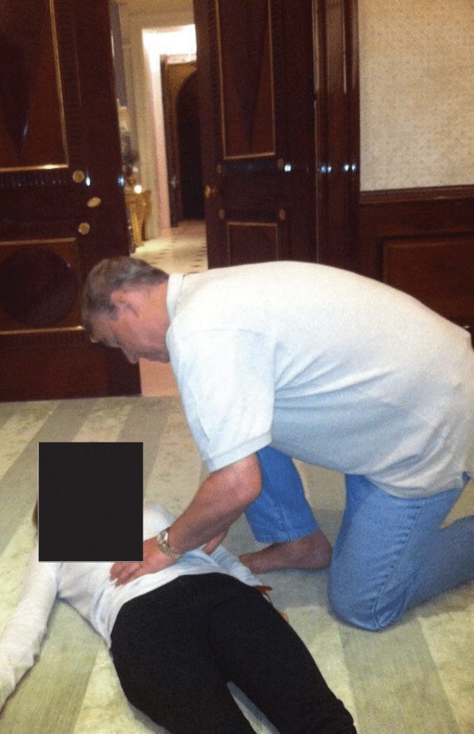 This undated photo at an undisclosed location released by the US Justice Department on January 30, 2026 as part of the Jeffrey Epstein files shows British former prince Andrew Mountbatten-Windsor kneeling over a woman lying on the floor. — AFP