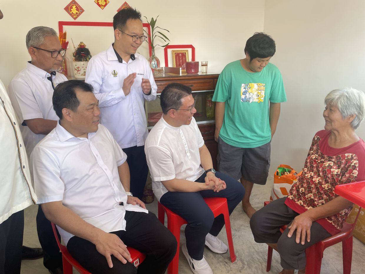 Nga Kor Ming chatting with Chan Fook Yan inside her newly built house.
