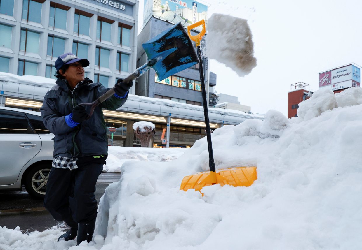 A man clearing snow from a walkway in Nagaoka, Japan, on Feb 7, 2026. - Reuters