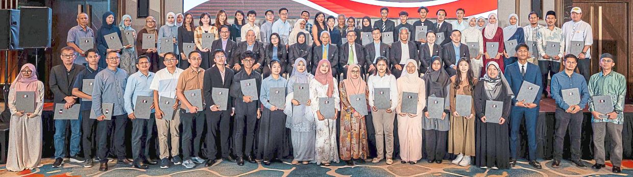 One for the album: Tengku Syed Badarudin and Lim (seated, fifth and sixth from left, respectively) with the awardees.