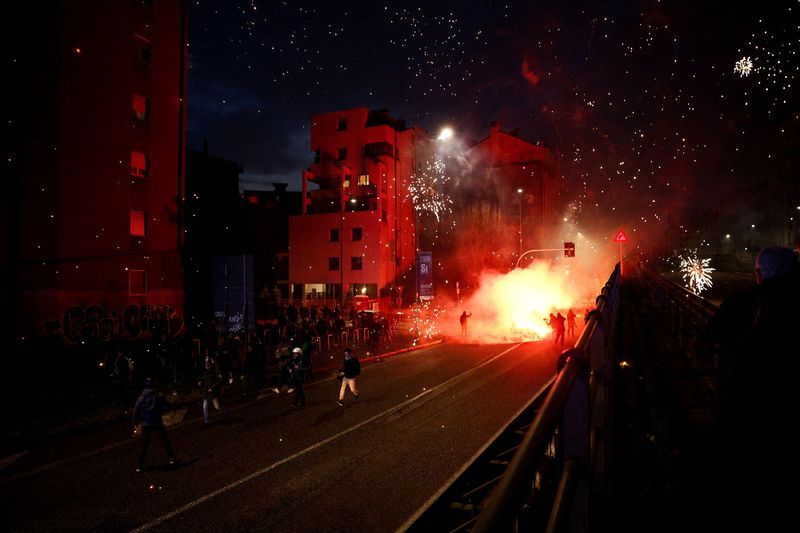 Hooded protesters throw flares at police at end of demonstration in Olympic host city Milan