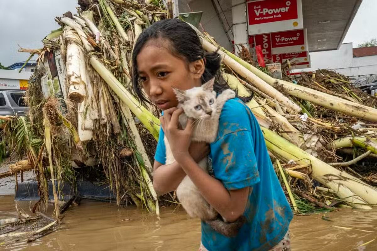 A girl still visibly distraught carries her pet in a storm-lashed area of Iligan City on Friday. - Photo: Jojo Sescon/contributor