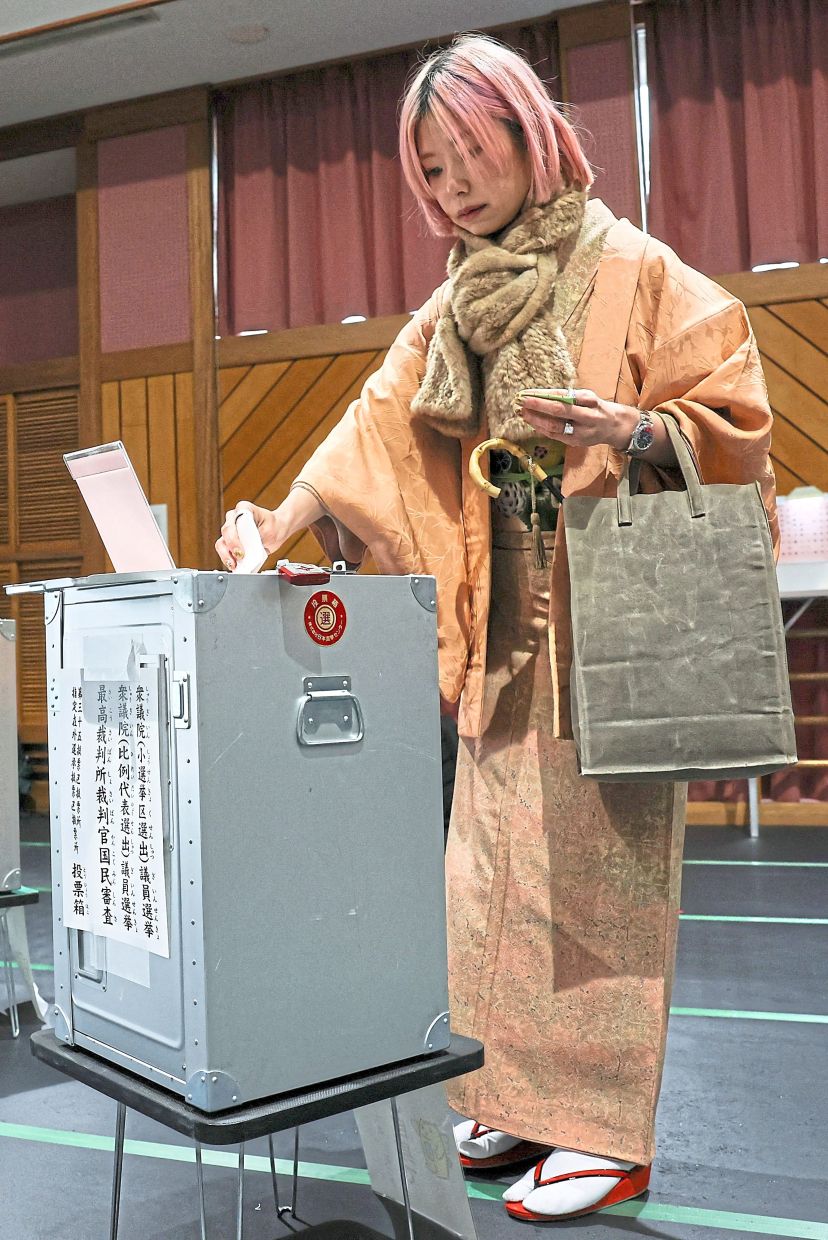 Civic duty:A voter wearing a traditional kimono casting her ballot at a polling station in Tokyo. — Reuters