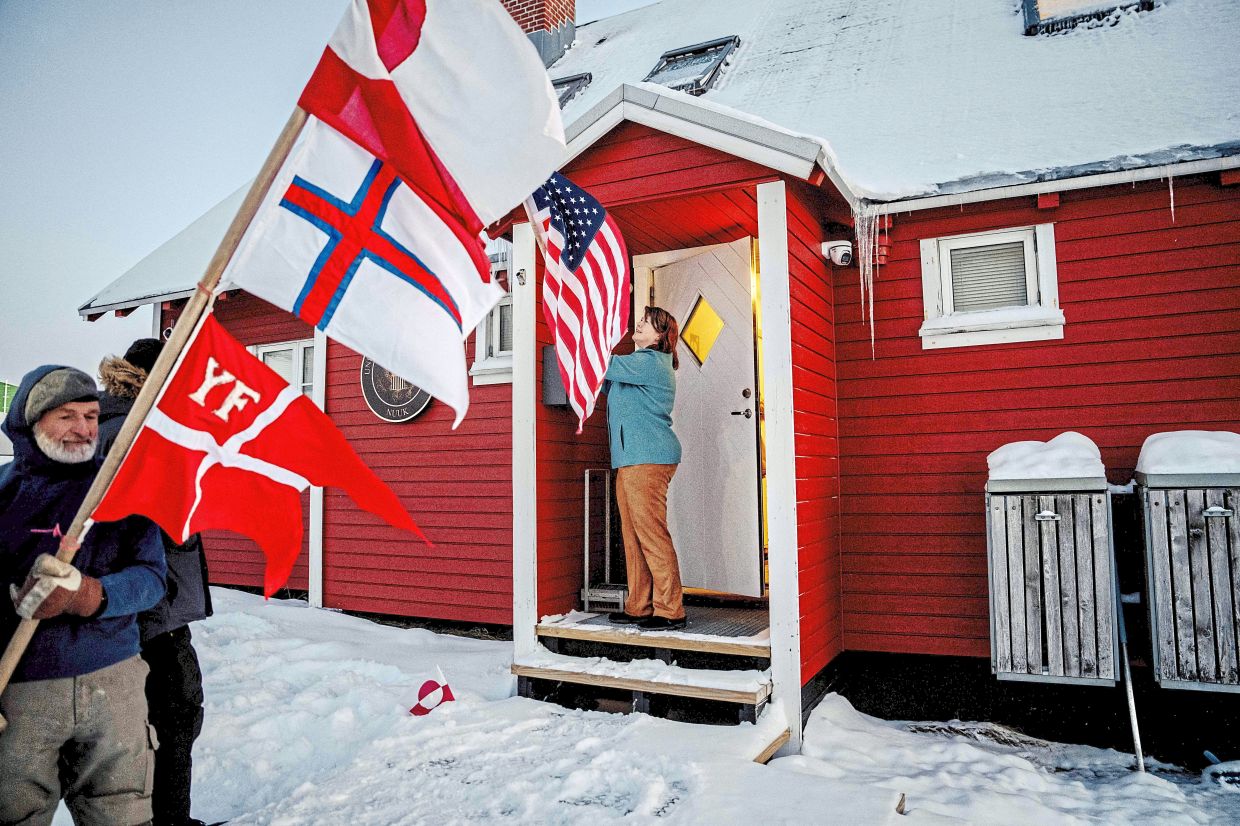 A protester holds flag outside the US consulate in Nuuk. — Ritzau Scanpix/AFP