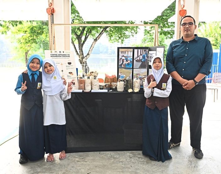 Asyraf showcasing coffee grounds being used to fertilise mushrooms.
