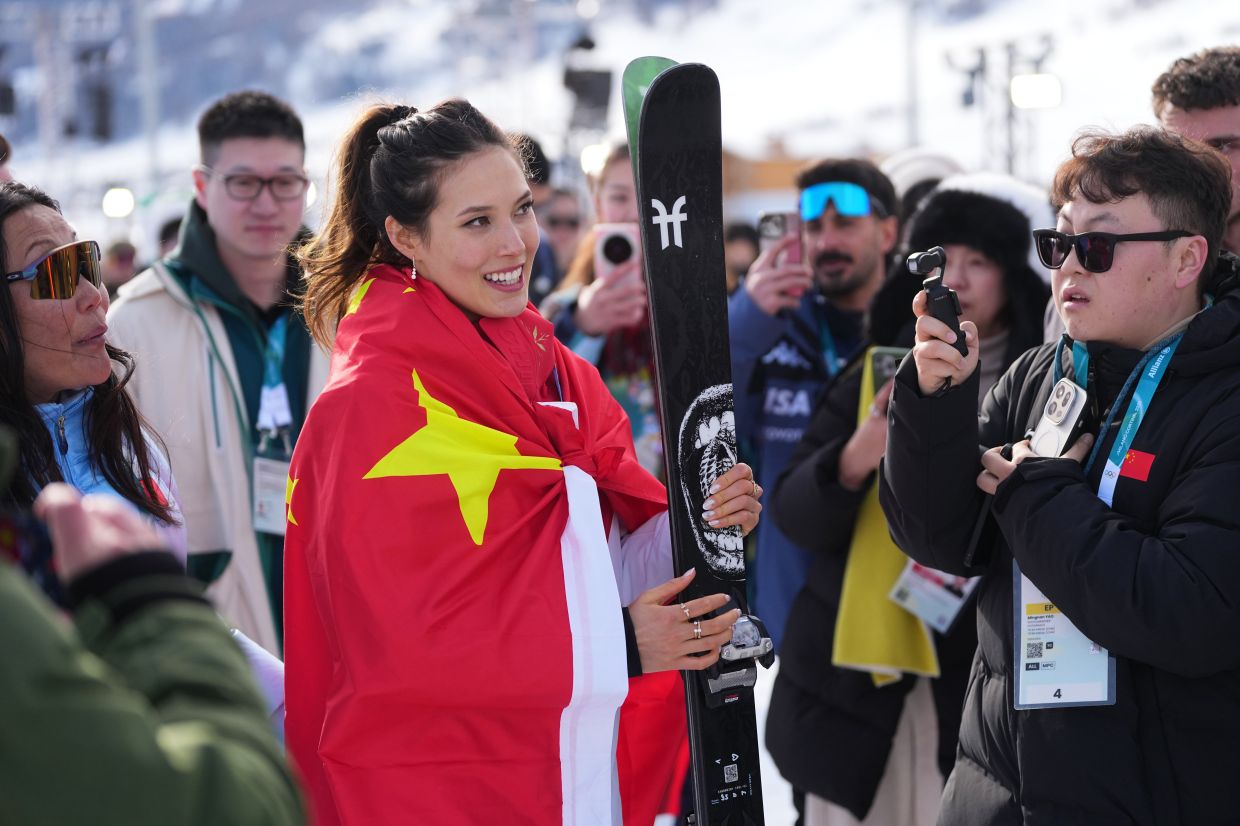 Silver medalist China's Eileen Gu wears a China flag after the women's freestyle skiing slopestyle finals at the 2026 Winter Olympics, in Livigno, Italy, on Monday, Feb 9, 2026. -- AP Photo/Lindsey Wasson
