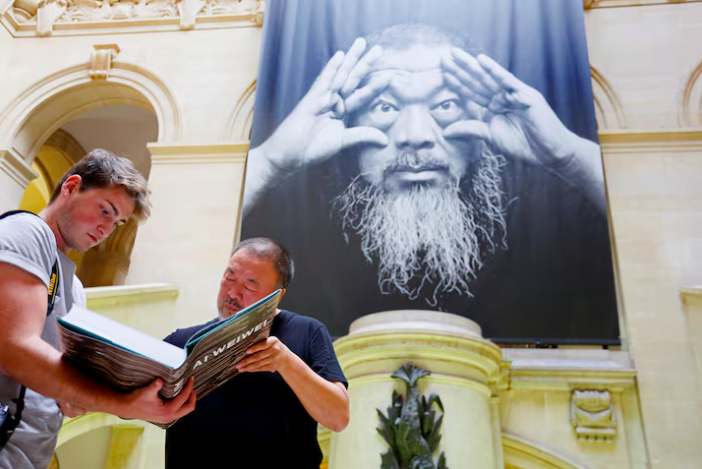 Ai signs a book during an exhibition at the Musee Cantonal des Beaux Arts in Lausanne, Switzerland in September 2017. Photo: Reuters