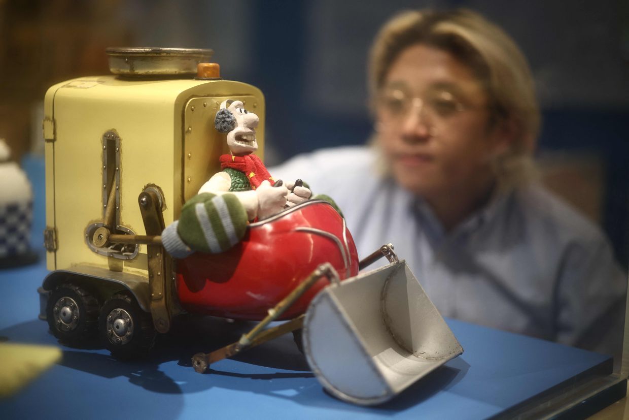 A visitor looks at the model of the Snowmanotron, from 'Wallace & Gromit's Cracking Contraptions' (2002). Photo: AFP
