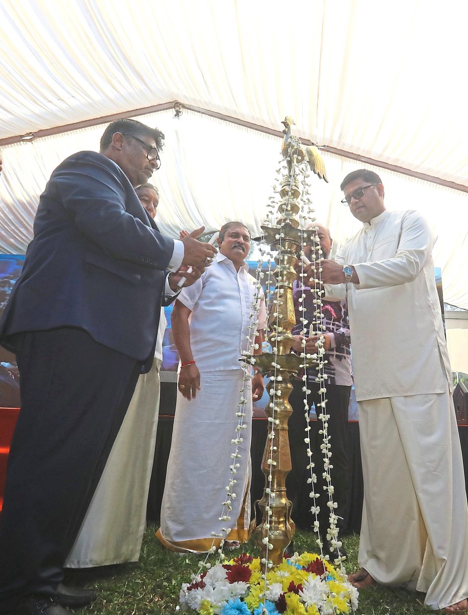 Mohamed Rizvi (right) lighting the oil lamp as part of the celebration. — Photos: AZLINA ABDULLAH/The Star