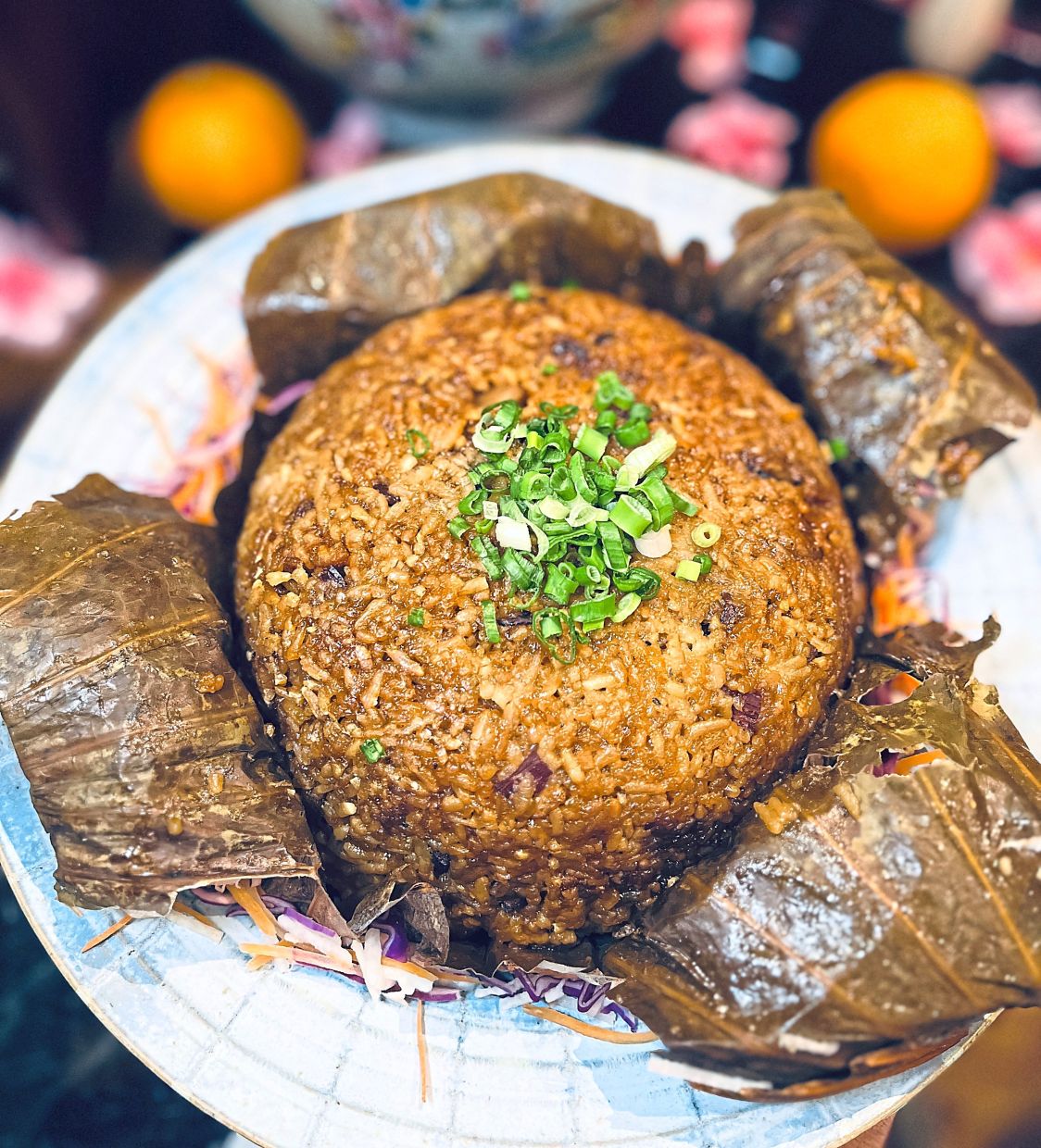 Steamed waxed meat rice is wrapped in lotus leaf infusing it with a delicate, earthy fragrance.