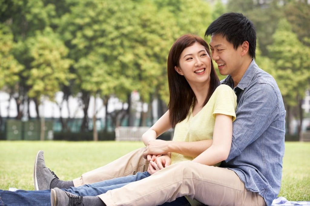 A content young Chinese couple relax in a park. For many others, the path to romantic happiness is not an easy one. - Photo: Shutterstock