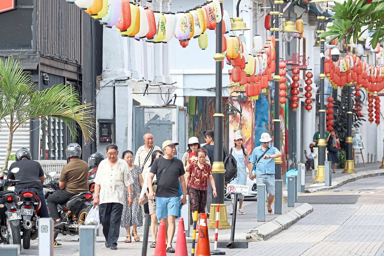 Tourists and locals strolling along Jalan Tan Hiok Nee in Johor Baru to soak up the festive atmosphere and do some last minute Chinese New Year shopping.