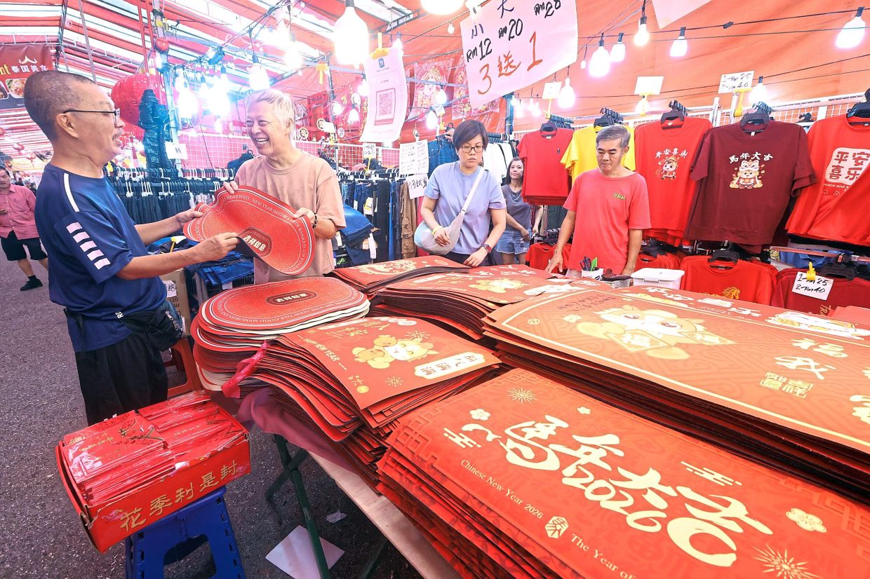 Customers choosing door mats to welcome Chinese New Year at the Johor Jaya Chinese New Year market.