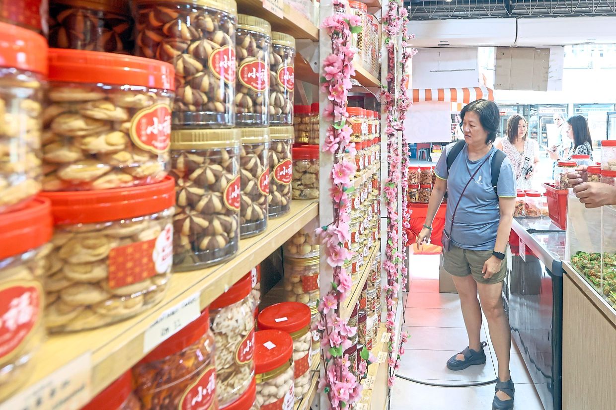 A customer choosing from the wide selection of Chinese New Year biscuits and snacks at a shop in Johor Baru.