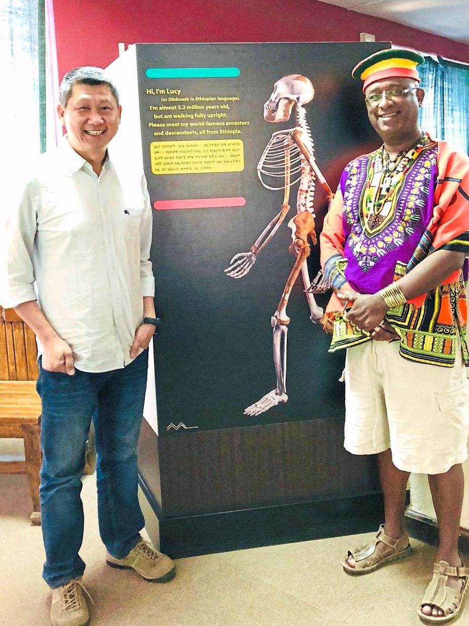 The writer (left) and a friend in a museum in Ethiopia, standing next to a poster of Lucy, the skeleton that’s millions of years old. — Photos: LEESAN