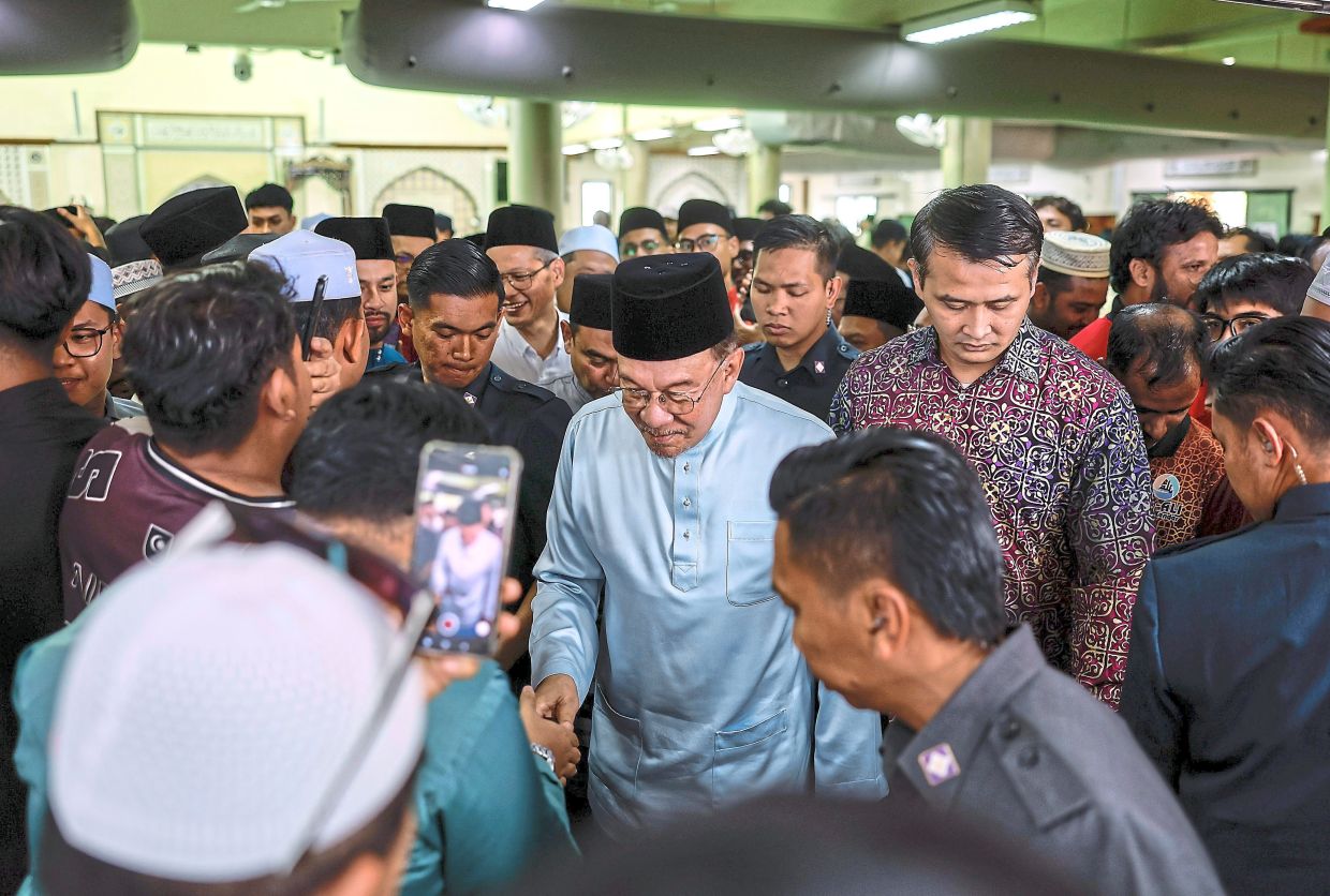 Justice in action: Anwar greeting people after performing Friday prayers at the Surau Politeknik Shah Alam. He assured that the probe into Azam’s alleged misconduct would be fully transparent, with no one shielded from scrutiny. — Bernama