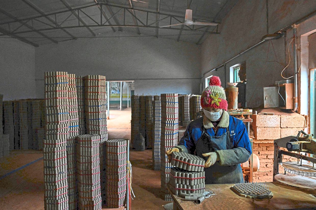A worker arranges fireworks shells inside a factory. Photo: AFP 
