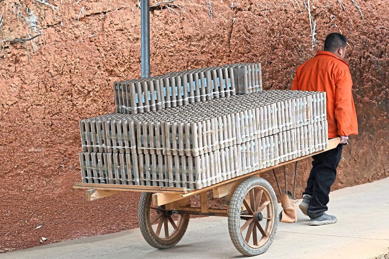 A worker hauls a cart stacked with fireworks through a factory in Liuyang, Changsha, in central China’s Hunan province. Photo: AFP