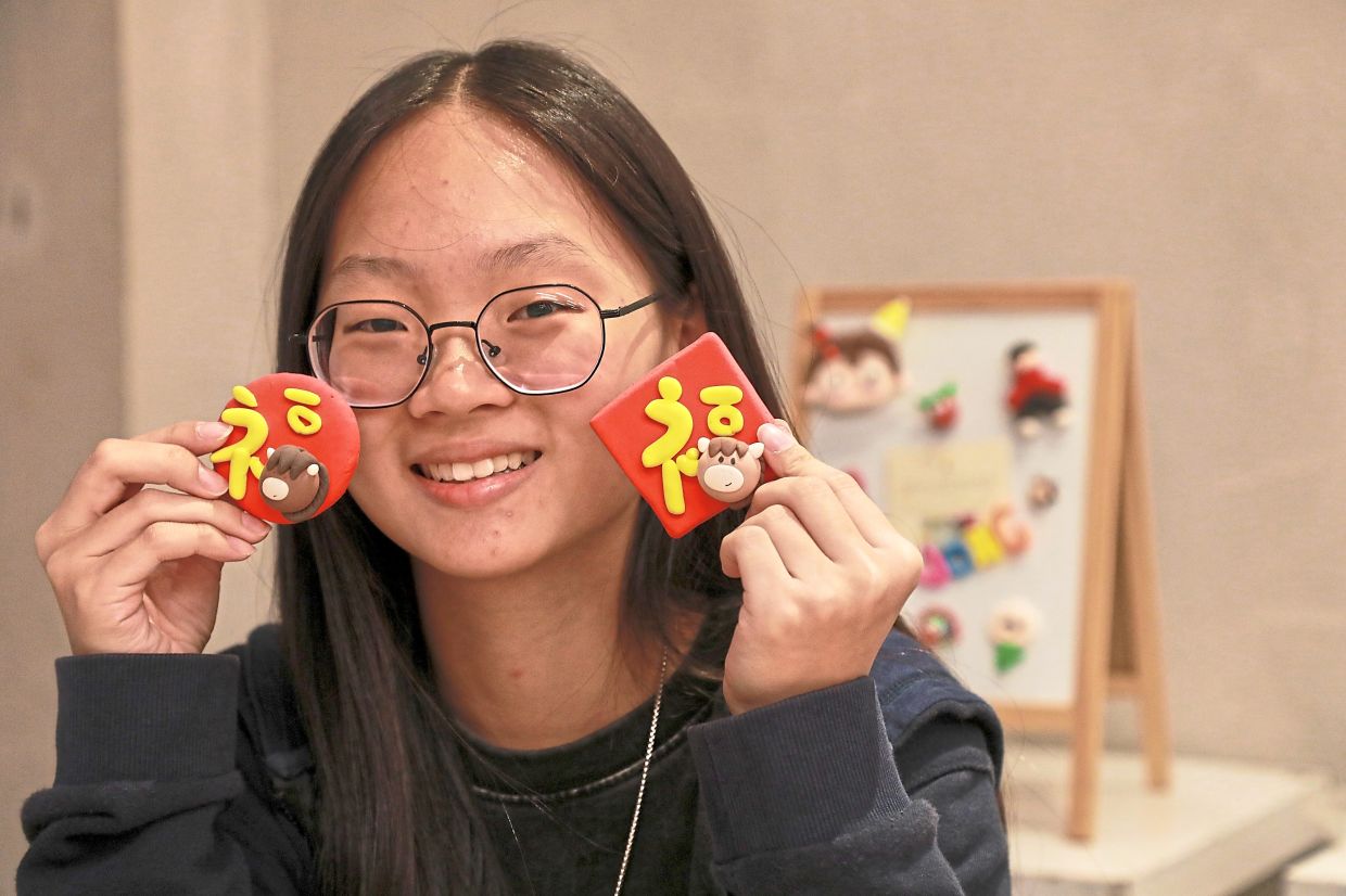 Wong showing off her CNY-themed fridge magnets at the event.