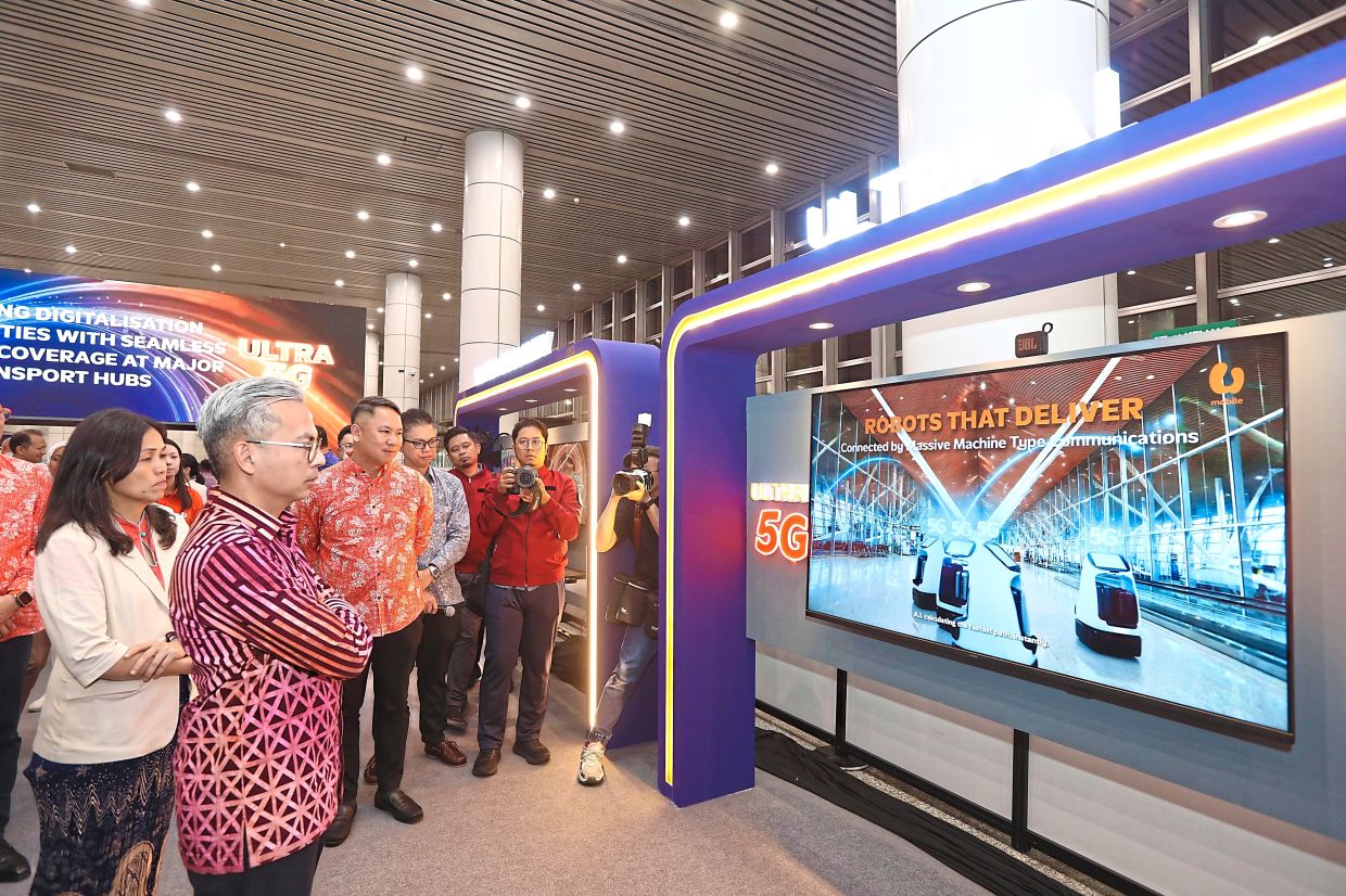 (From left) Teo and Fahmi watching the robotics demonstration during U Mobile’s ULTRA5G launch.