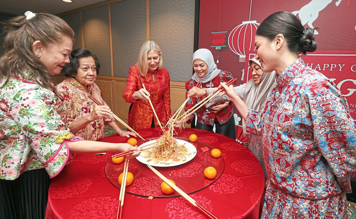 Permaisuri Norashikin (third from right), Pernille (third from left) and other guests also tossing ‘yee sang’ for good fortune.