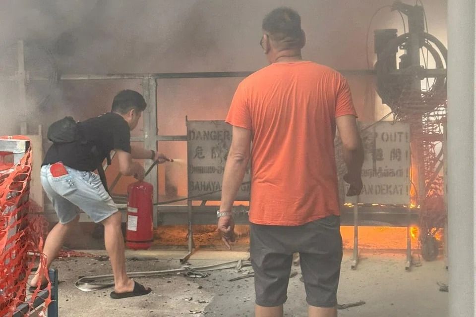 Police officers and members of the public put out the flames using fire extinguishers before SCDF arrived. - Photo: SHIN MIN DAILY NEWS READER
