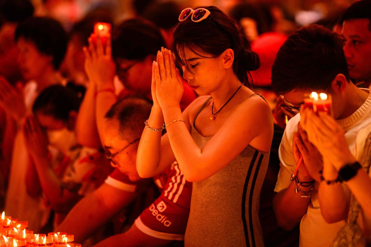 People pray in Wat Mangkon Kamalawat temple on the first day of the Lunar New Year of the Horse in the Chinatown area of Bangkok on Tuesday, February 17, 2026. -- Photo by ANTHONY WALLACE / AFP